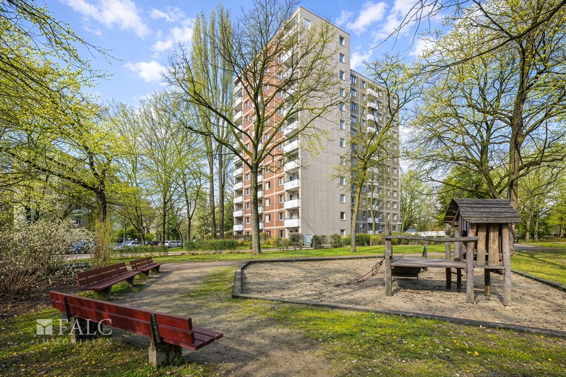 Gebäude komplett mit Spielplatz im Frühling